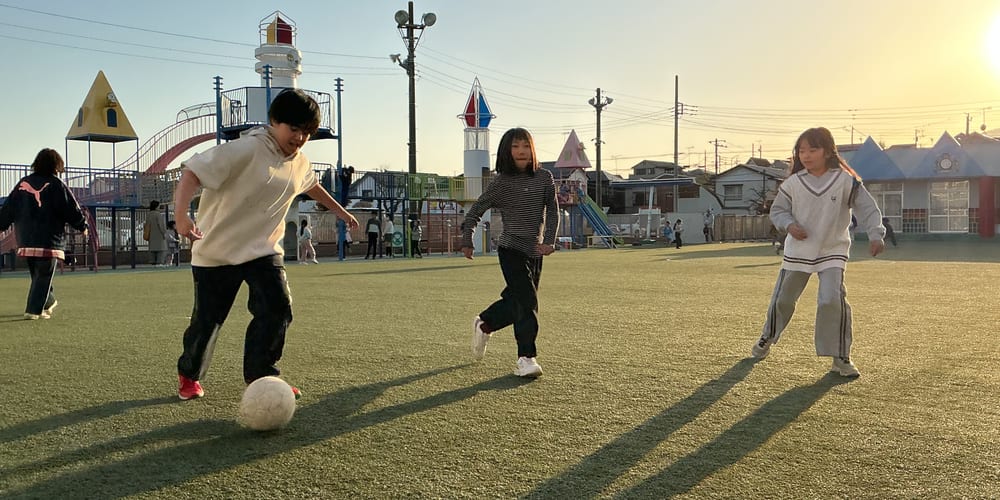 園庭でボール遊びをする学童クラブの子どもたち