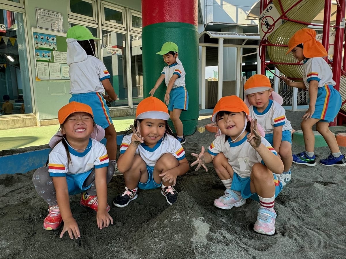 砂場で遊ぶ預かり保育の子どもたち