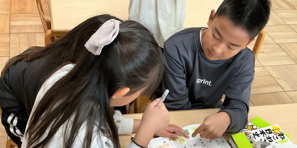 学童クラブで学校の宿題に取り組む子どもたち