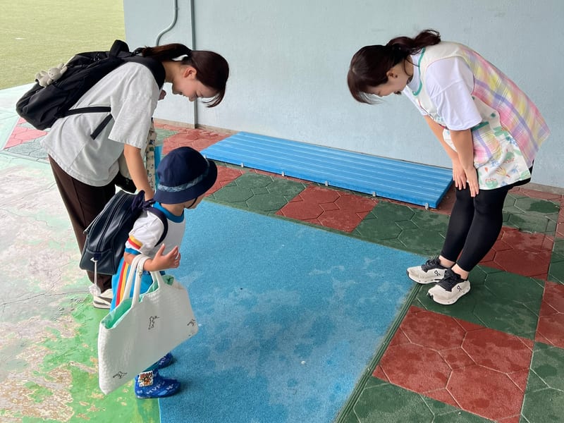 保護者と一緒に、先生と朝のごあいさつをする園児