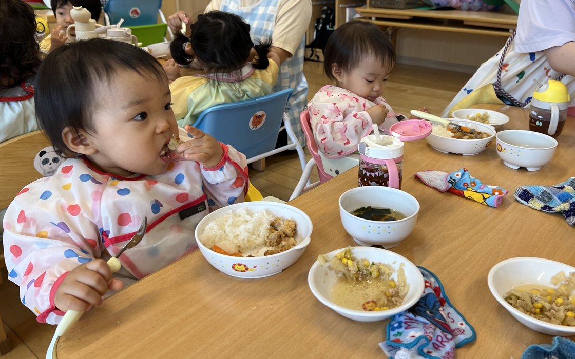 スプーンを使って自分で給食を食べる子どもたち