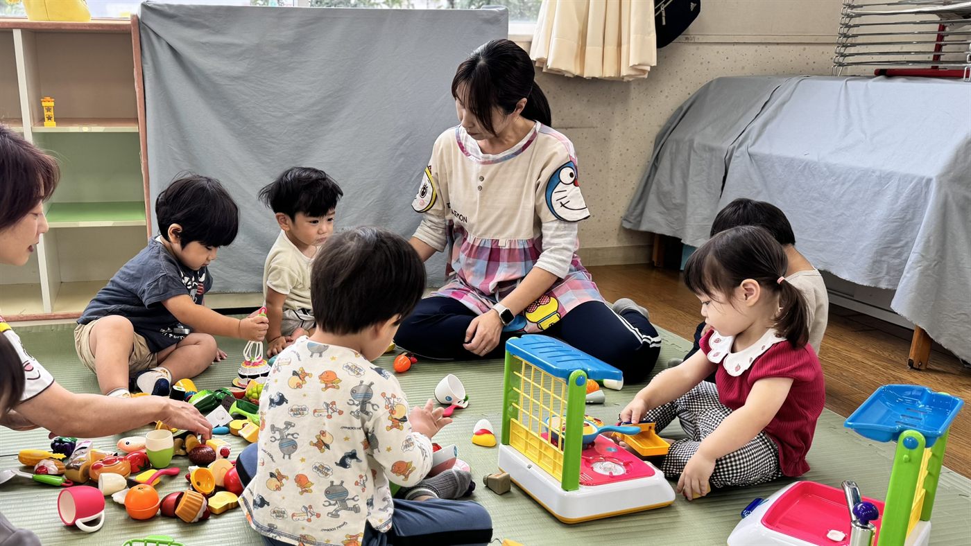 ままごとのおもちゃで遊ぶ子どもたちと先生