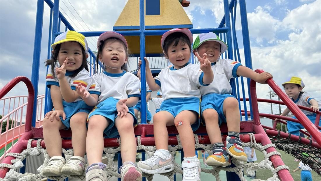 大型遊具に並んで座る園児たち